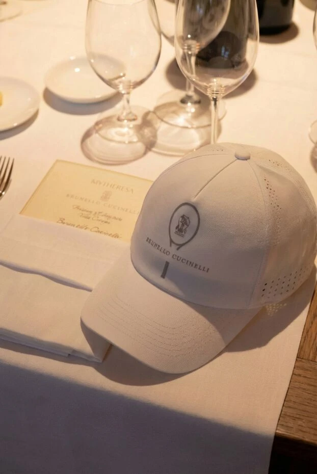 A sports white cap made of breathable fabric with perforations.
 - photo 2